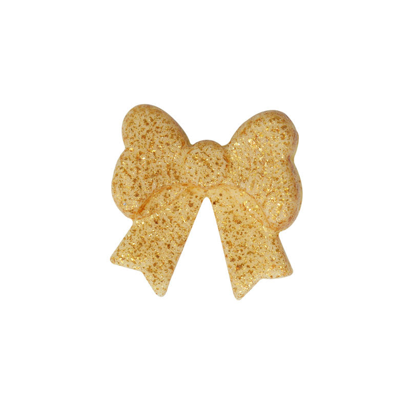 Närbild på en gyllene ätbar rosett mot vit bakgrund