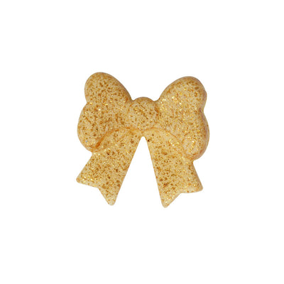 Närbild på en gyllene ätbar rosett mot vit bakgrund