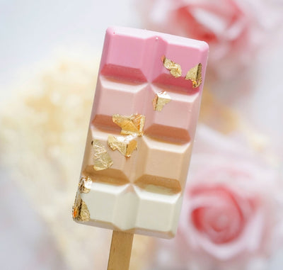 Mini-dessert i chokladkakeform med rosa och vita nyanser dekorerad med ätbart guldblad.