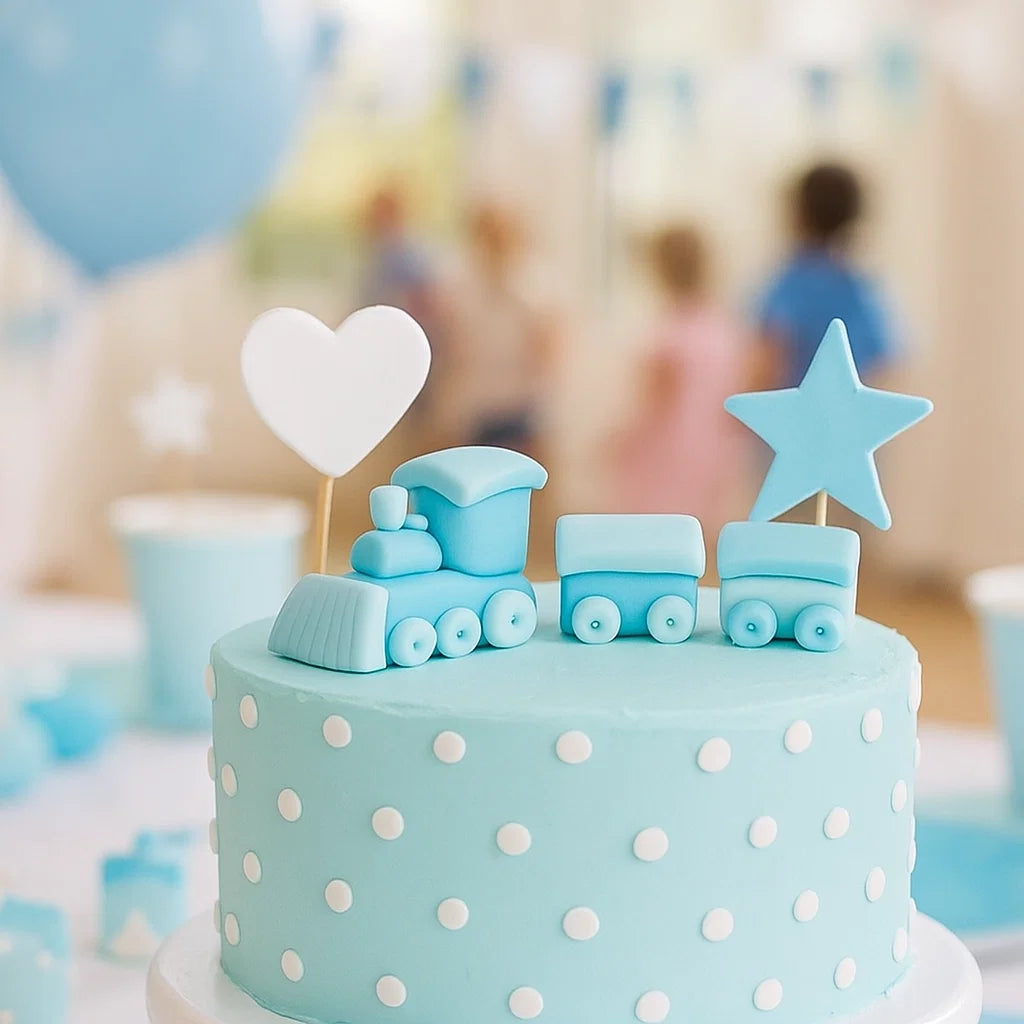 Ätbar tårtdekoration i form av blått tåg i sockerpasta på ljusblå tårta med vita prickar – perfekt för dop och babyshower