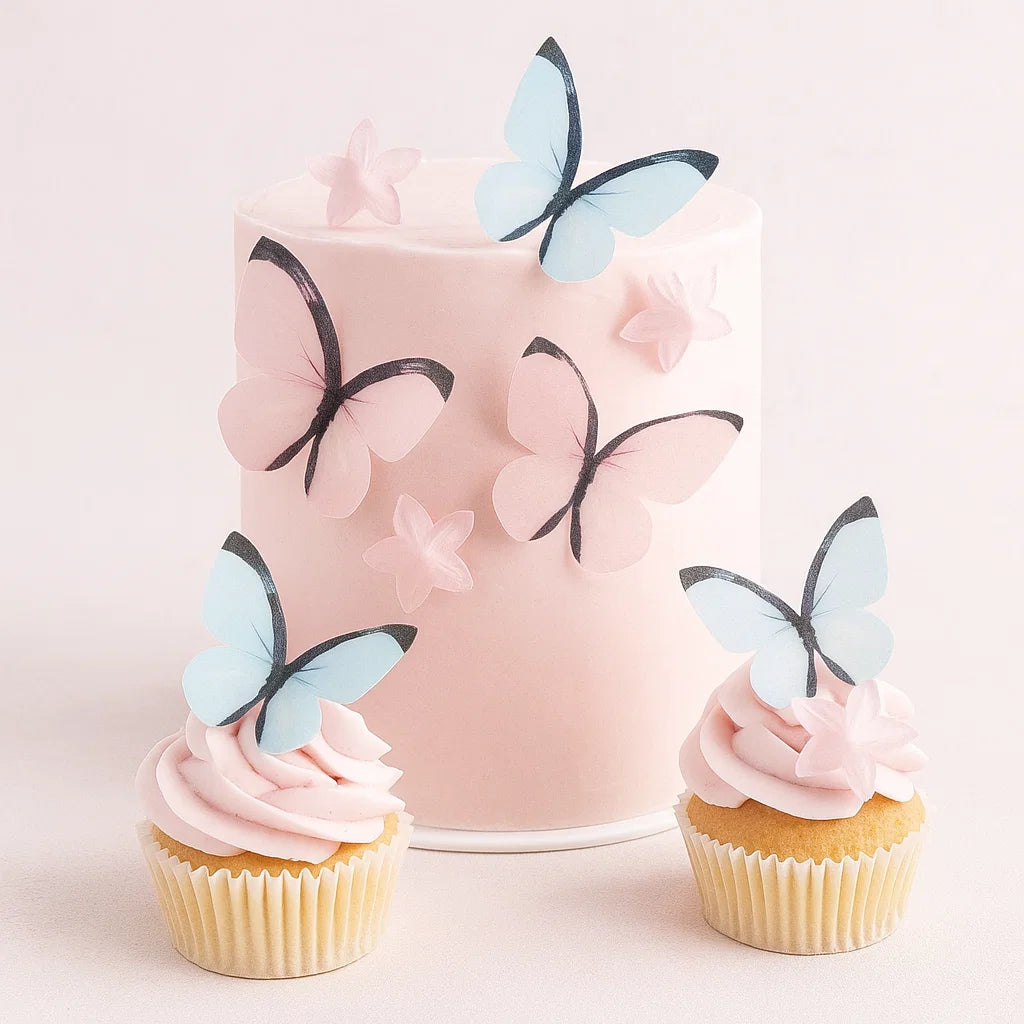 Rosa tårta och cupcakes dekorerade med ätbara fjärilar och blommor i pastellrosa och blått från Wilton.