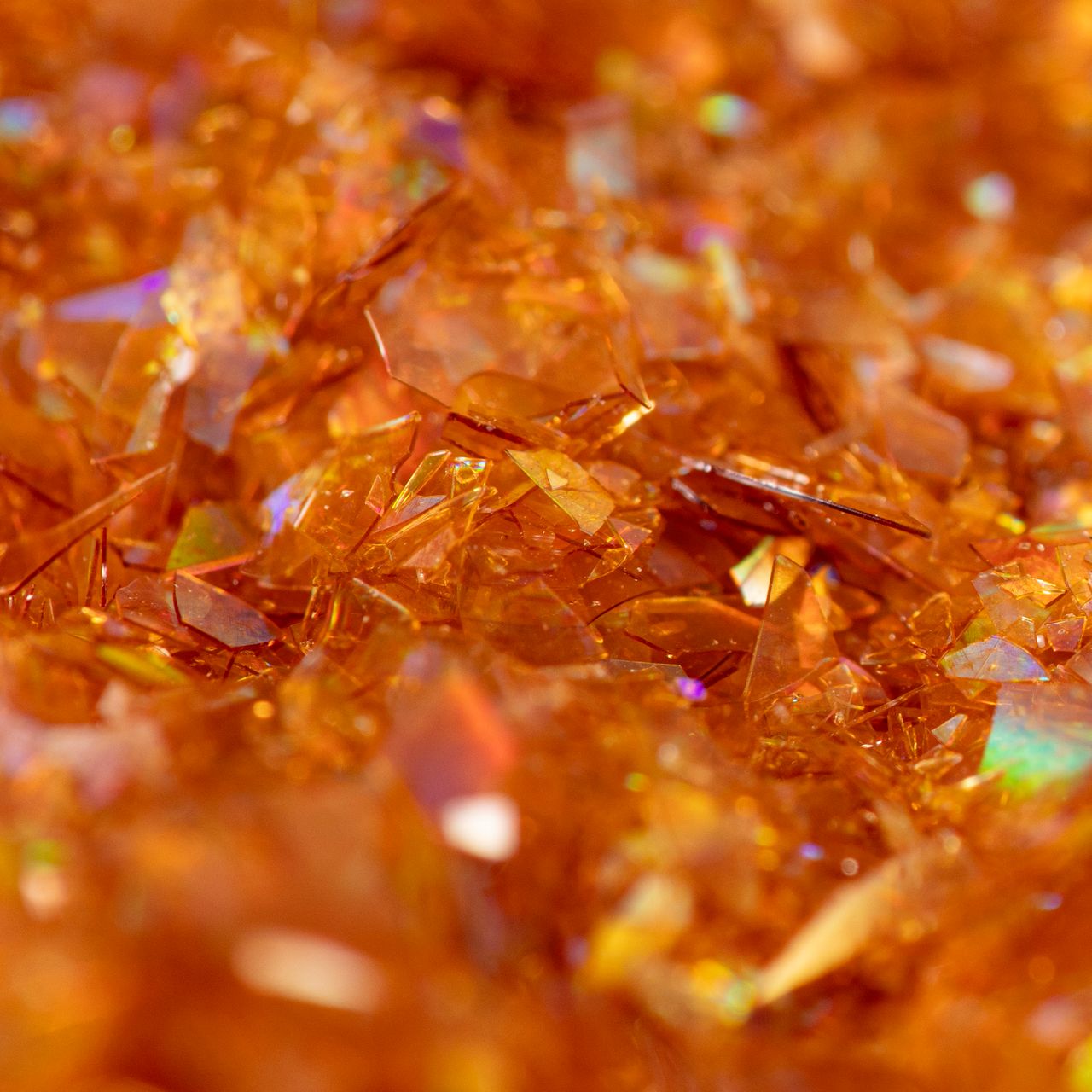 Närbild på skimrande guldglitterflingor från PME Magic Sparkles med iriserande effekt.