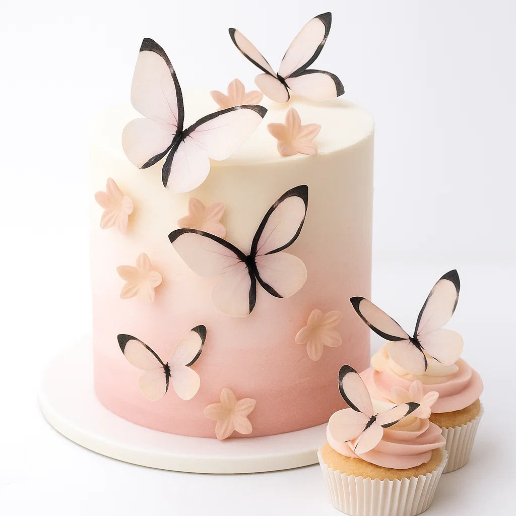 Ätbara wafer-fjärilar och blommor i ombre rosa på vit och rosa tårta
