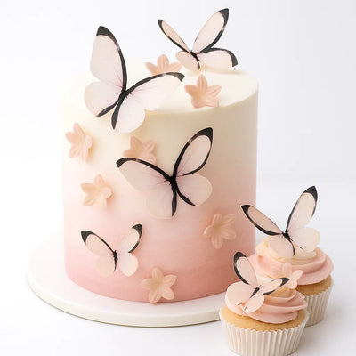 Ätbara wafer-fjärilar och blommor i ombre rosa på vit och rosa tårta