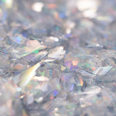 Närbild på silvriga ätbara glitterflakes med iriserande skimmer