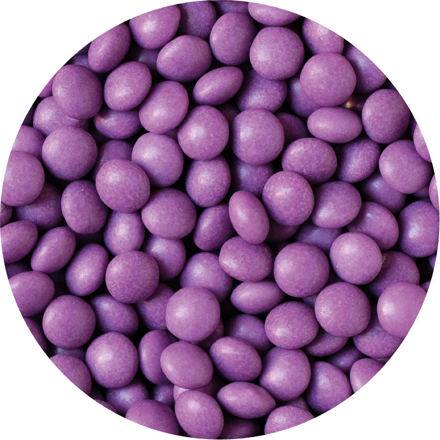 Närbild på violetta chokladpärlor från Decora, glansigt strössel för dekorering av tårtor, cupcakes och desserter.