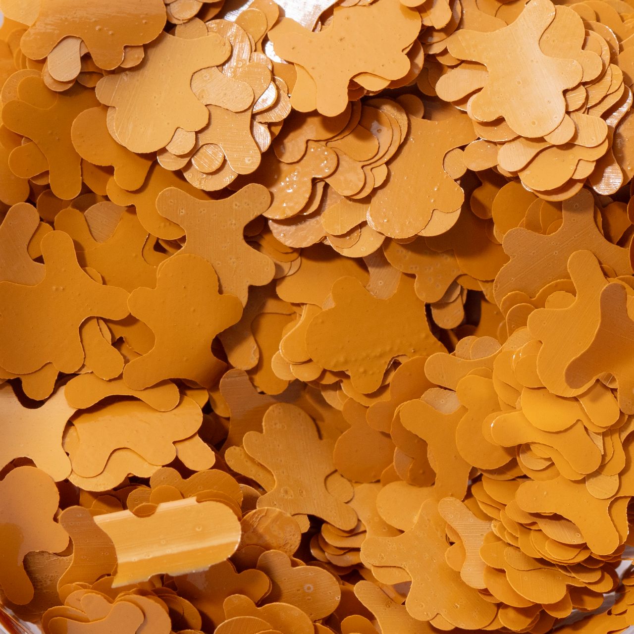 Närbild på gyllenbruna glitterströssel i form av platta pepparkaksgubbar.