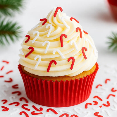 Cupcake dekorerad med röda och vita polkagrisformade glitterfigurer.
