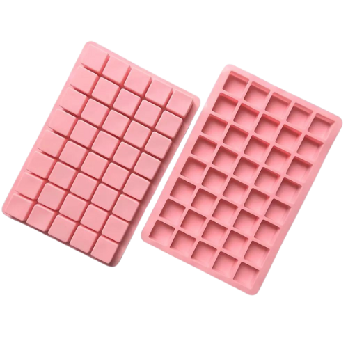 Två rosa silikonformar med små fyrkantiga fack för choklad eller godis.