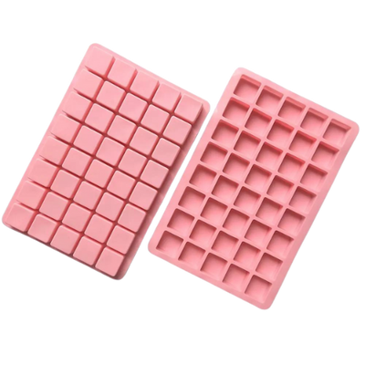 Två rosa silikonformar med små fyrkantiga fack för choklad eller godis.