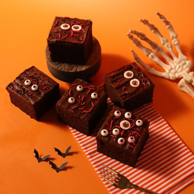 Chokladrutor dekorerade med PME Bloody Eyes Halloweenströssel och skelettrekvisita.