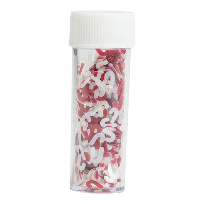 Närbild på ett rör med röda och vita ätbara polkagrisströssel i glittermaterial.