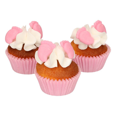 Rosa ätbara bebisfötter som ätbar dekoration på cupcakes