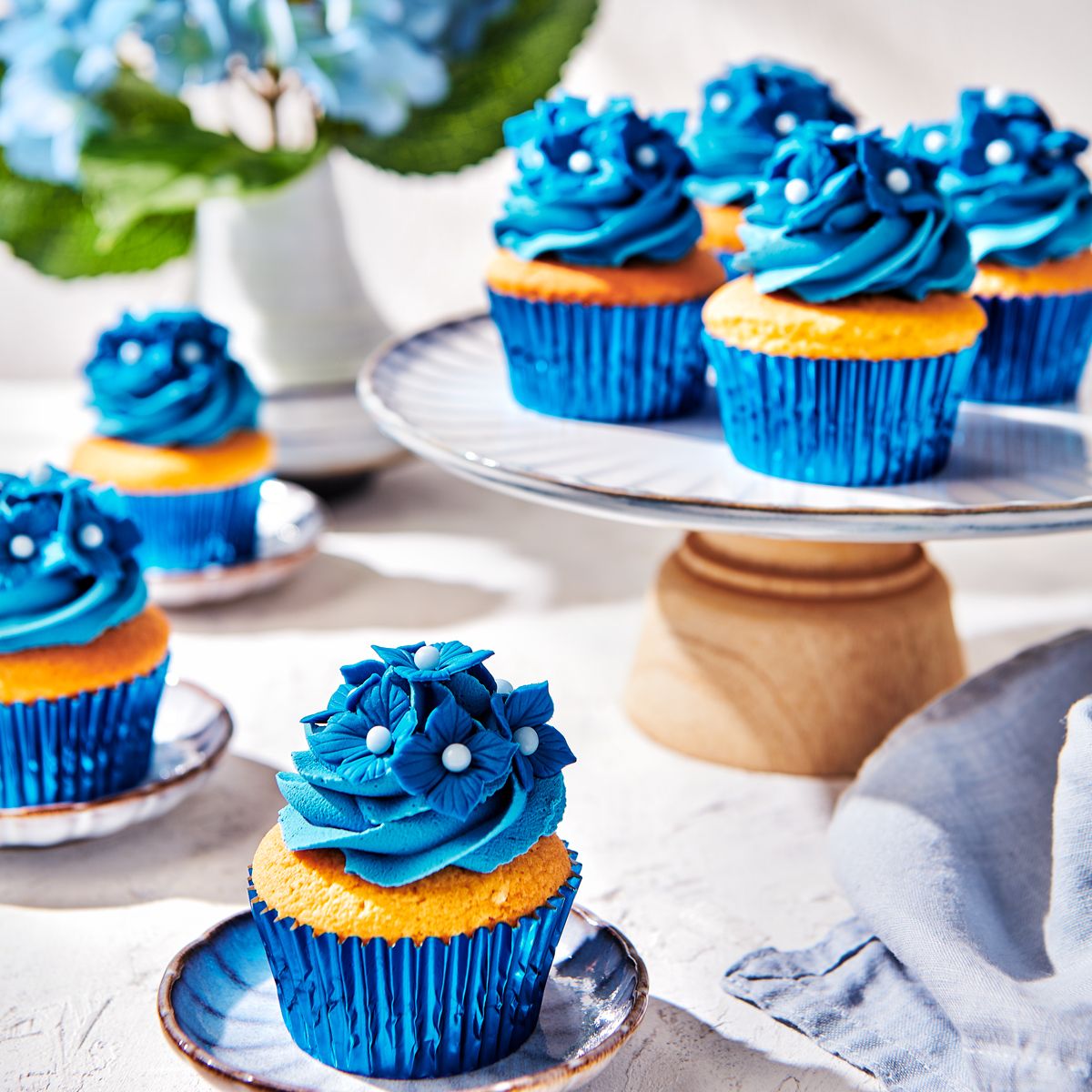 Cupcakes dekorerade med blå frosting och blommor gjorda av Bella Blue sockerpasta
