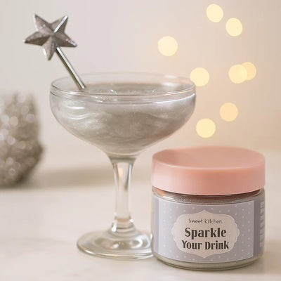 Cocktailglas med glittrande silverdryck och burk med SweetKitchen Sparkle Your Drink