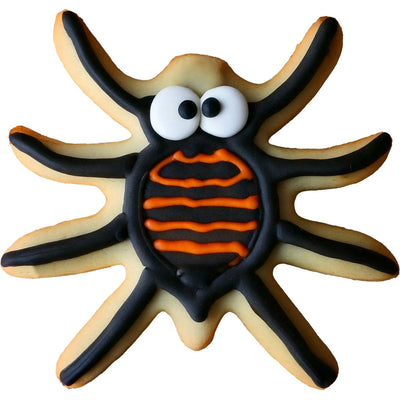 Kaka i form av spindel dekorerad med svart och orange glasyr samt ögon i sugarpaste.