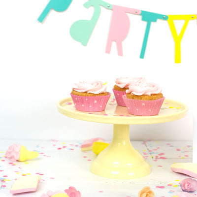 Serveringsexempel med rosa cupcakes på ett gult tårtfat i melamin