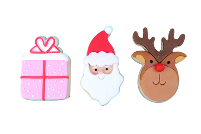 Dekorerade julkakor formade som paket, tomte och ren mot vit bakgrund